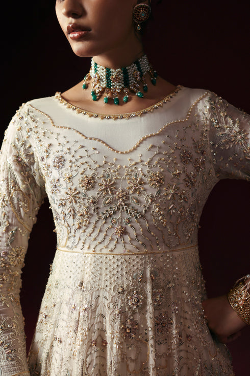 Model wearing NAQSHI Nurzaad 3‑piece off‑white ensemble with embroidered maxi and silk trousers